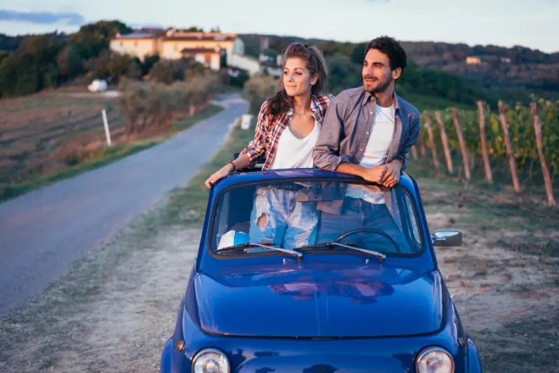 Pareja de viaje en un coche pequeño de segunda mano