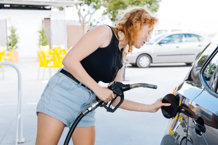 Mujer repostando combustible en su coche de ocasión